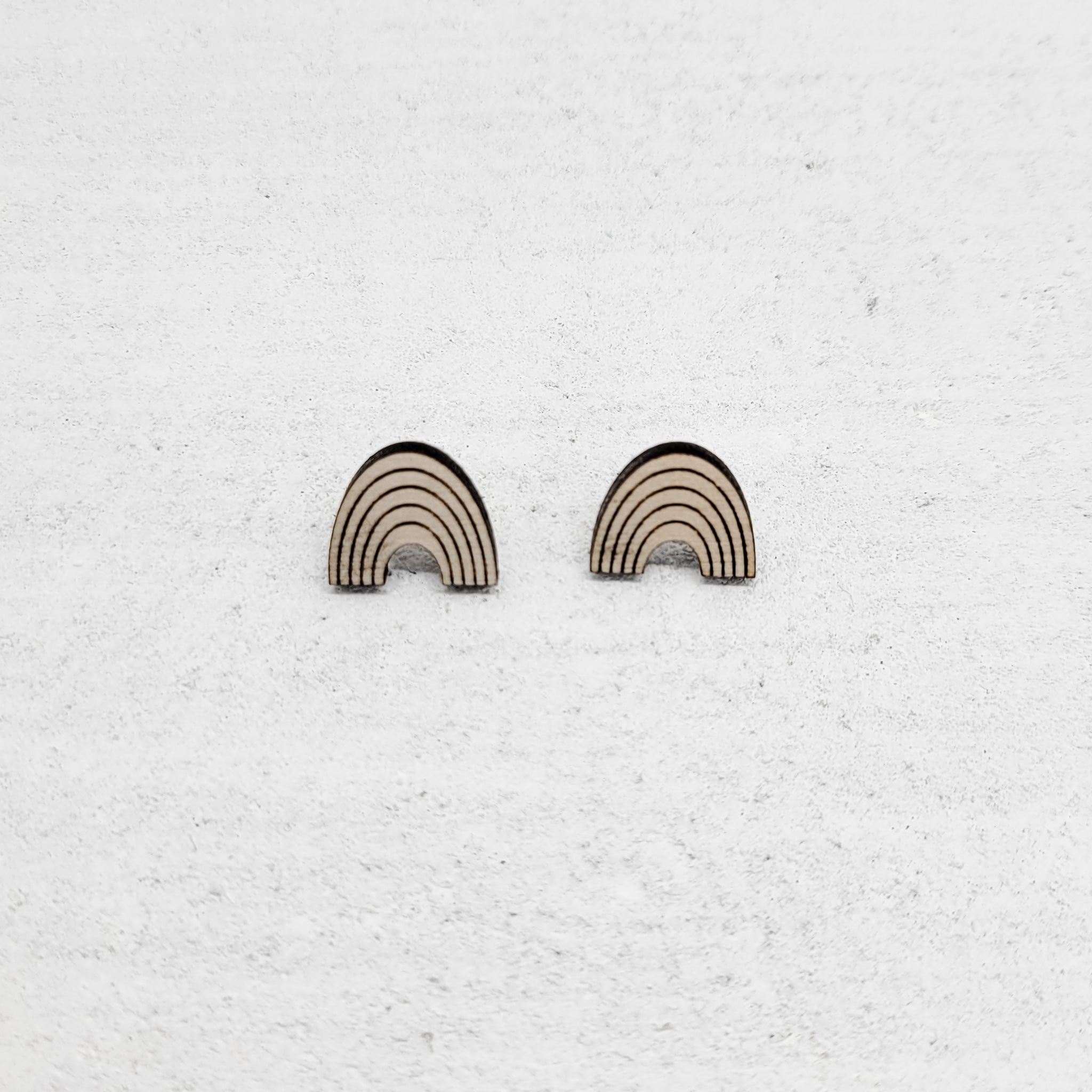 Rainbow earring made out of wood. Purchases support women who have aged out of foster care.