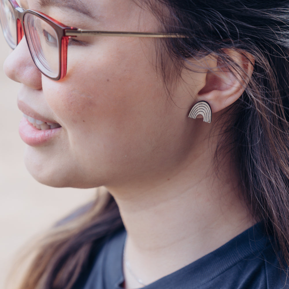 Rainbow earring made out of wood. Purchases support women who have aged out of foster care.